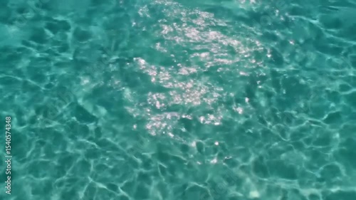 Clear teal ocean water glistening under sunlight; ideal for travel brochures, vacation websites, and naturethemed designs.
