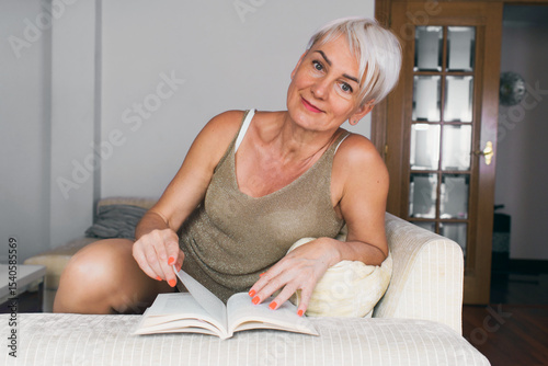 Mature woman relaxing with a book at home photo