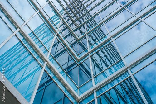 Looking Up at Modern Office Building with Glass Windows Reflecting Sky