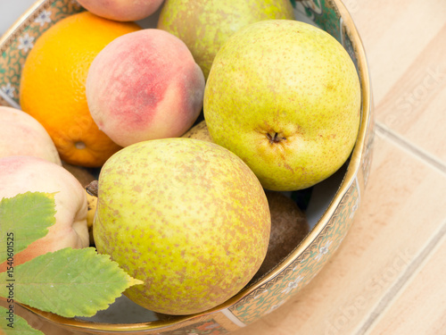Bananas, peaches and pears on a plate.