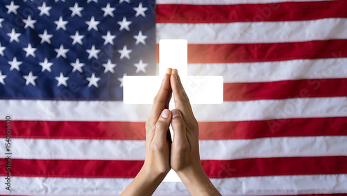 Praying hands before glowing cross and american flag