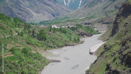 River Chenab flowing between the Himalayan mountain valley as seen from Pattan valley in Lahaul, Himachal Pradesh, India during the summer season. River flows in between the mountains.