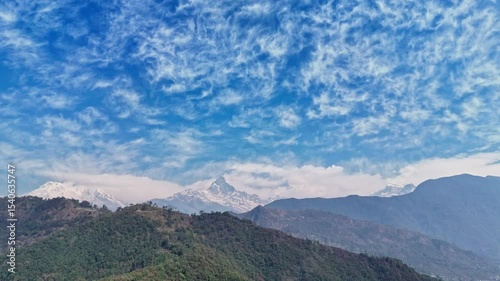 Machhapuchhare (Fishtail) Mountain with Lush Hills and Snow-Capped Peaks Under Dramatic Sky