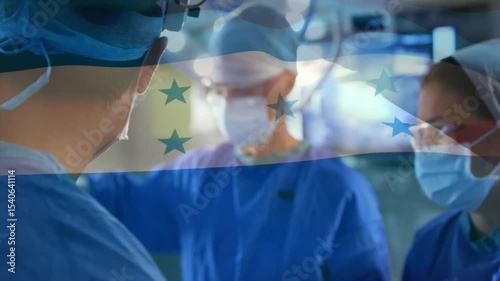 Surgeon focusing on patient during surgery after Honduras flag rippling, assistants handing tools