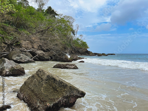 Beautiful rocky beach with white sand, blue sky and crystal clear waters