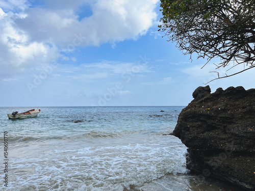 Island with stunning seascape – beach, rock, boat, and vegetation background