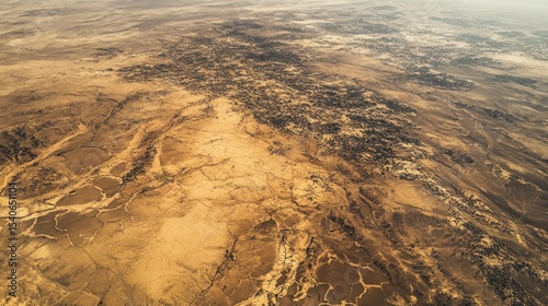 An aerial view of barren, cracked land, emphasizing the devastating impact of desertification and climate change.