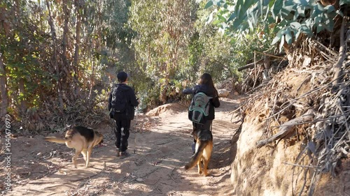 Latin American teen hikers enjoying a walk with their german shepherd dog on a sunny day in Elqui Valley, Chile.