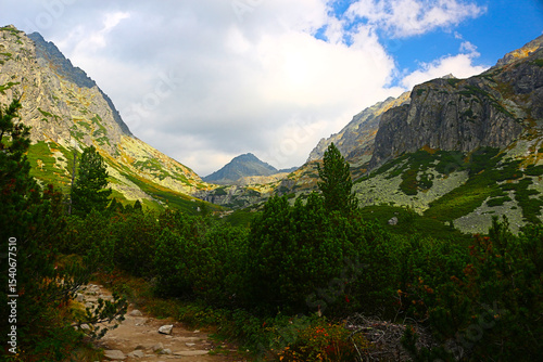 Majestic mountain valley with a winding hiking trail.