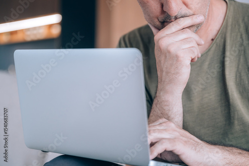 Telecommuter freelancer working online on a laptop computer from his living room