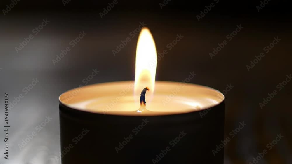 Single candle flame burning dark background Single candle flame burning dark background
