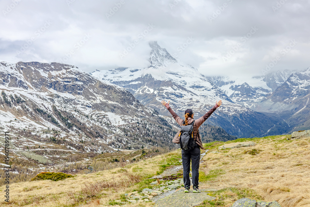 Obraz premium Hiker enjoying the breathtaking view of snow-capped mountains in Zermatt, Switzerland