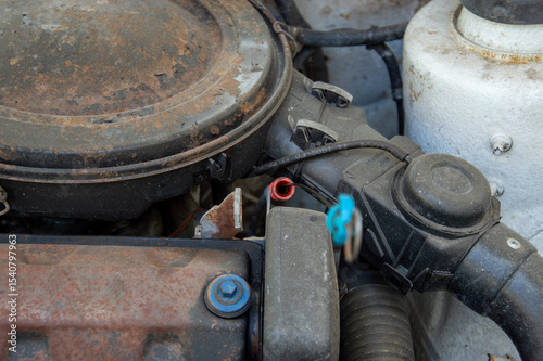Close-up view of a vintage engine compartment highlighting weathered machinery parts and connectors in varied conditions