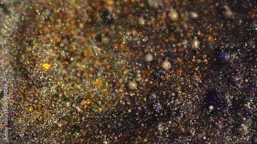 Golden glitter particles shimmer in macro close-up