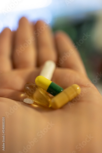 Hand holding assorted colorful capsules and pills for healthcare and medication concept