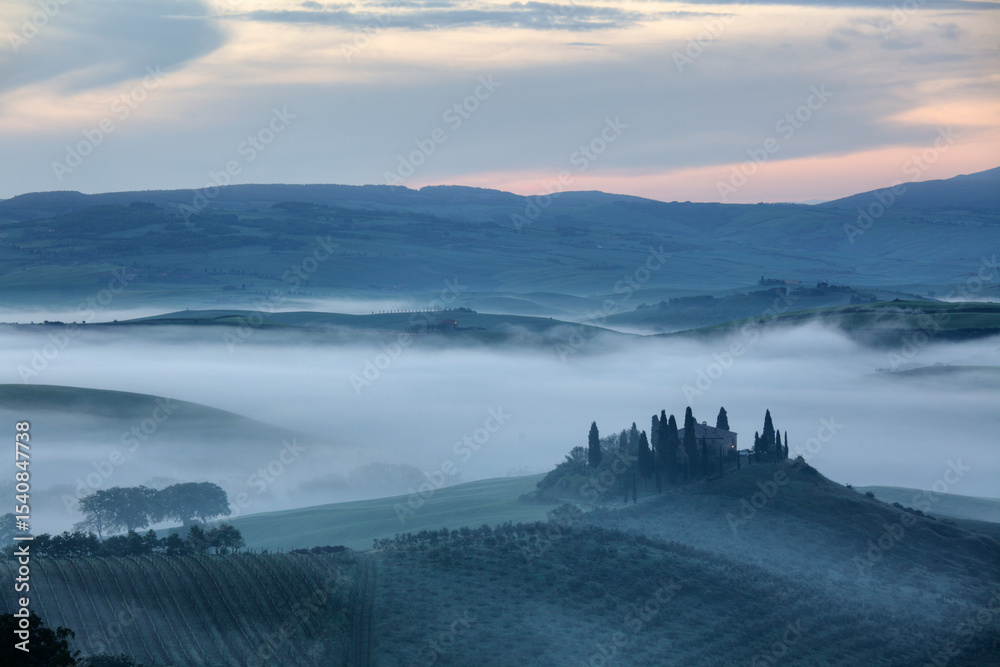 Naklejka premium The Belvedere farmhouse in Val d’Orcia with early morning fog, San Quirico d'Orcia, Tuscany, Italy