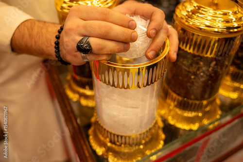 A man selects natural menthol crystals on Souq in Oman.