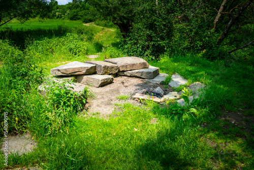 Firepit with bench and Rock Seats near a little River in the bavarian Forests Germany