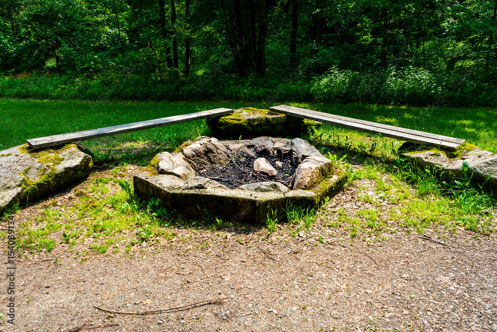 Firepit with bench and Rock Seats near a little River in the bavarian Forests Germany Firepit with bench and Rock Seats near a little River in the bavarian Forests Germany