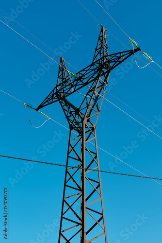 High voltage power tower against clear blue sky