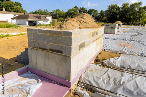 Construction site with cinderblock foundation at residential property during works daytime
