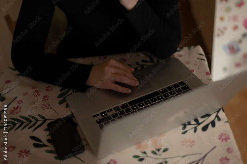 Obraz premium A woman is seated comfortably at a table, focusing intently as she uses her laptop computer to accomplish her tasks or browse online