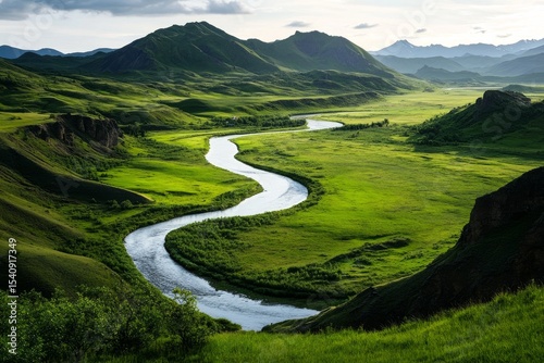 Scenic View of a Winding River Through Lush Green Valley in a Mountainous Lan...