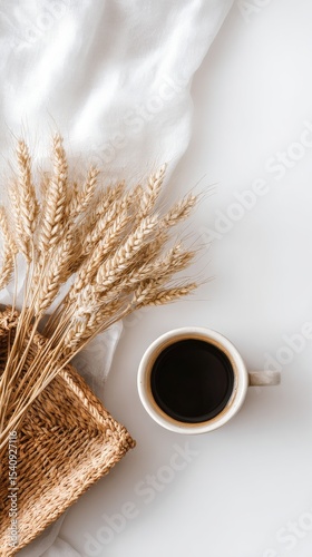 Warm Coffee Cup Next to Dried Wheat on a White Surface in a Cozy Setting