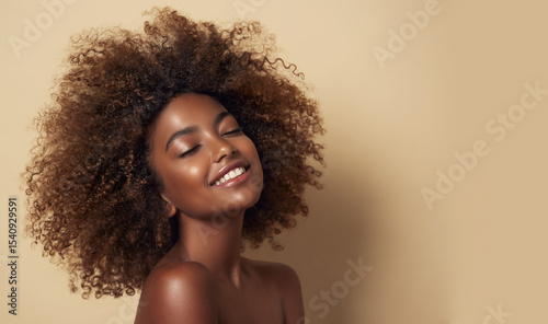 Beauty portrait of african american woman with clean healthy skin on beige background. Smiling dreamy beautiful afro haitstyle  girl.Curly black hair