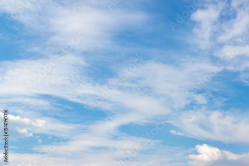 Expansive blue sky filled with soft white clouds, creating a serene atmosphere, ideal for backgrounds or design projects, conveying tranquility and openness