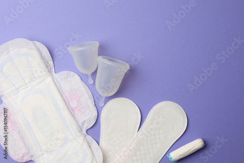 Eco-friendly menstrual cup and other feminine hygiene products on a bright background
