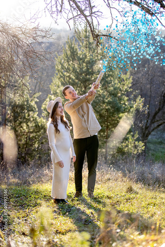 Happy couple happily celebrating their pregnancy surrounded by blue confetti
