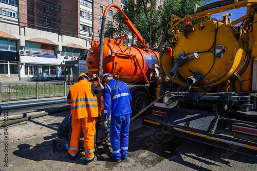 Workers cleaning sewer and pumping sewage into septic tank