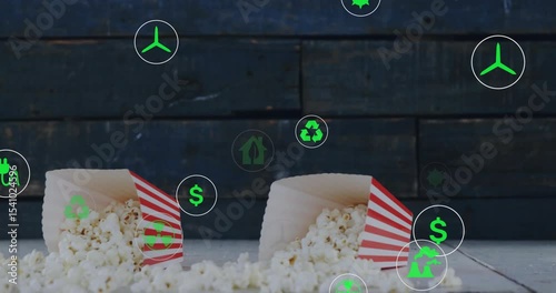 Dropping popcorn tubs spilling kernels green icons floating and circling showing sustainability