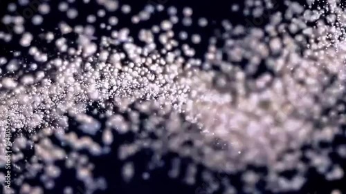 Abstract animation concept of golden particles for celebrating birthdays and holidays. 4k loop bokeh background with light particles and stars rising up on a dark background. Animation footage