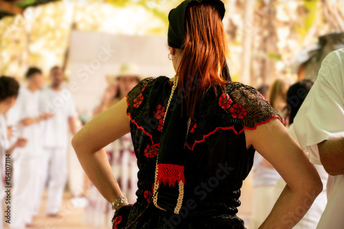 woman from behind wearing typical costumes of the pombagira entity of Brazilian candomblé.