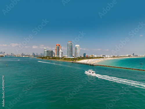 Sailboat journey along Miami shoreline. Miami landmark near the coast, luxury yacht. Miami harbor with vessels, sailboats, and yachts.