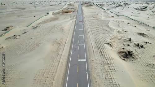 Drone view of asphalt road passing through in Gobi desert on sunny autumn day in Hotan, Kashgar, Xinjiang, China, 4k real time footage, travel concept. 