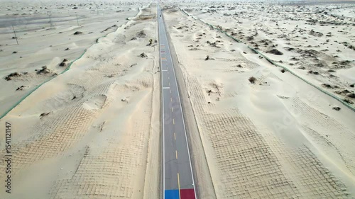 Drone view of asphalt road passing through in Gobi desert on sunny autumn day in Hotan, Kashgar, Xinjiang, China, 4k real time footage, travel concept. 