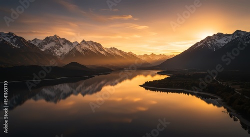 Snowy Mountains Reflecting in Calm Lake at Sunset