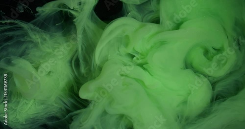 Smoke stream. Dye spread. Bright color green paint explosion flow. Art fume wave spray abstract blur black sparkling water background.