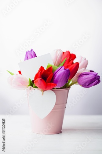 Fototapeta Naklejka Na Ścianę i Meble -  Flat illustration tulip bouquet is being placed in pink bucket with white card and heart tag
