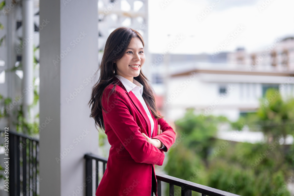 Fototapeta premium Young businesswoman smiling and relaxing on balcony during break time