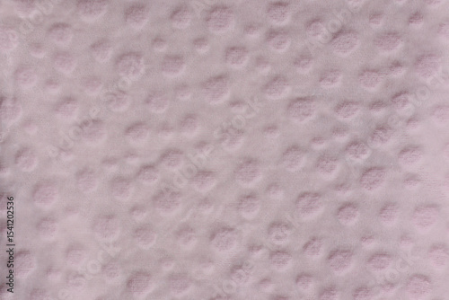 Light pink fabric with textured circular dots close-up abstract background