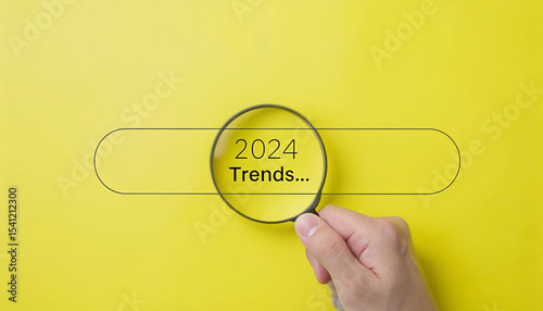 Looking Ahead Magnifying Glass Focuses on 2024 Trends in a Search Bar on a Bright Yellow Background Representing