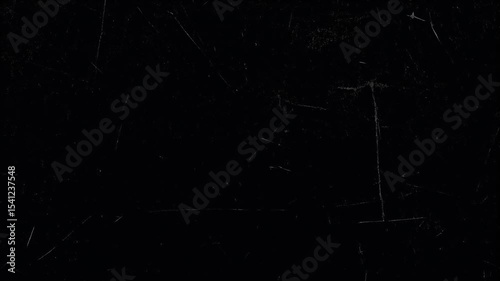 A dark, textured surface is displayed, featuring scratches and subtle variations in tone.