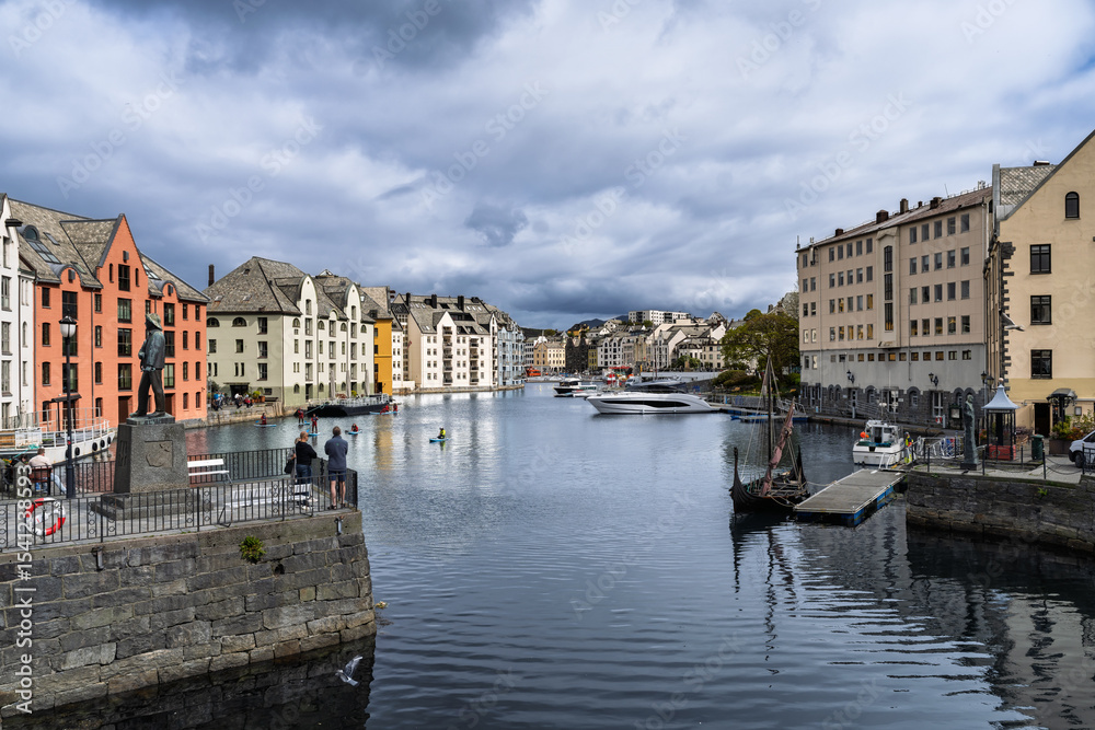 Naklejka premium Scenic Waterfront View of Colorful Buildings Along a Canal with Boats, Aalesund, Norway