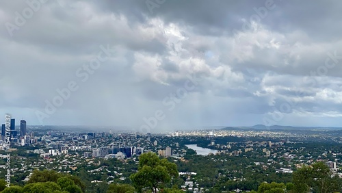 Brisbane City Skyline from Mt. Coot-tha Lookout – Urban Landscape with Skyscrapers, Green Foreground, and Moody Sky