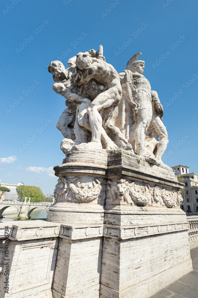 Obraz premium Marble sculpture group on the Ponte Vittorio Emanuele II in Rome, Italy, depicting warrior figures against a clear blue sky