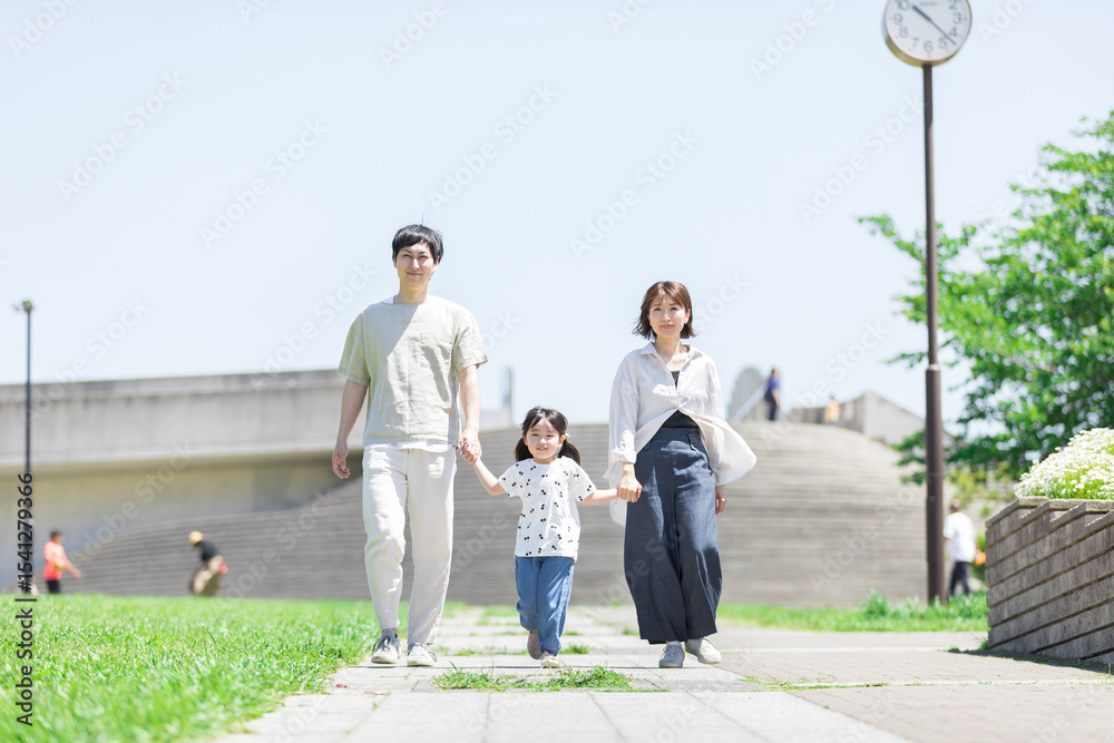 Fototapeta premium 手を繋いで屋外を散歩する親子